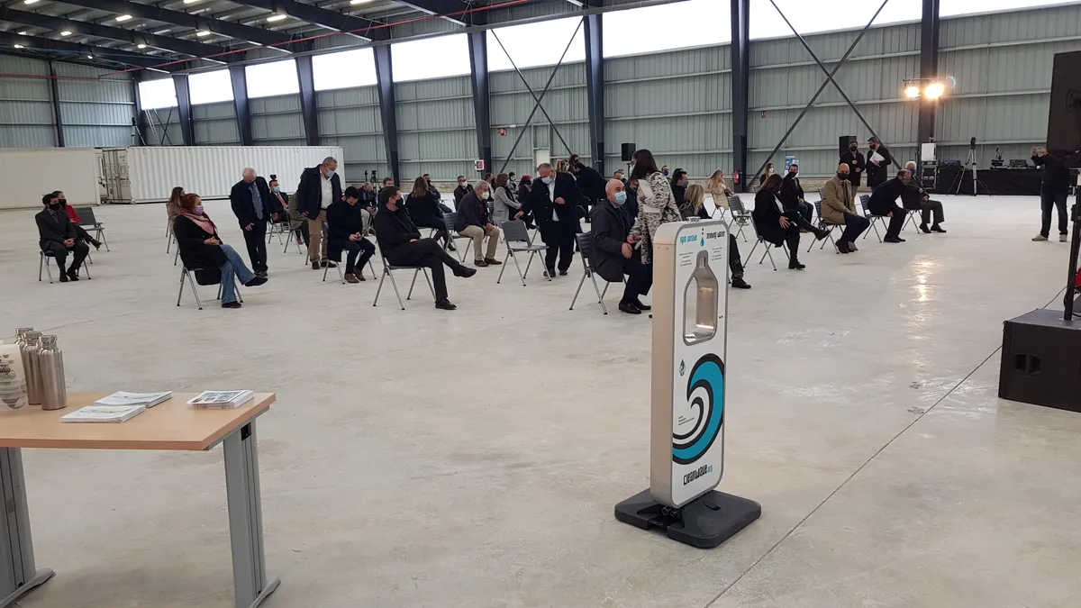 Público con mascarilla sentado y distanciado en la inauguración de la planta de Ca na Putxa, con un dispensador de agua de Cleanwave en primer plano