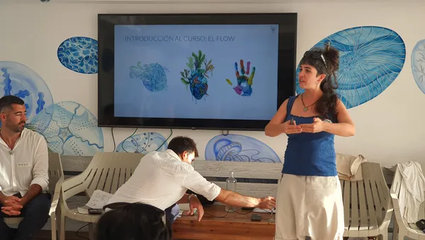 Facilitadora del curso Dirección Consciente explicando el módulo Cabeza, Corazón, Manos ante un grupo de tripulantes