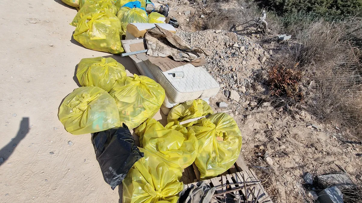 Bolsas de basura y escombros de un vertido ilegal recogidos junto a una carretera de Ibiza
