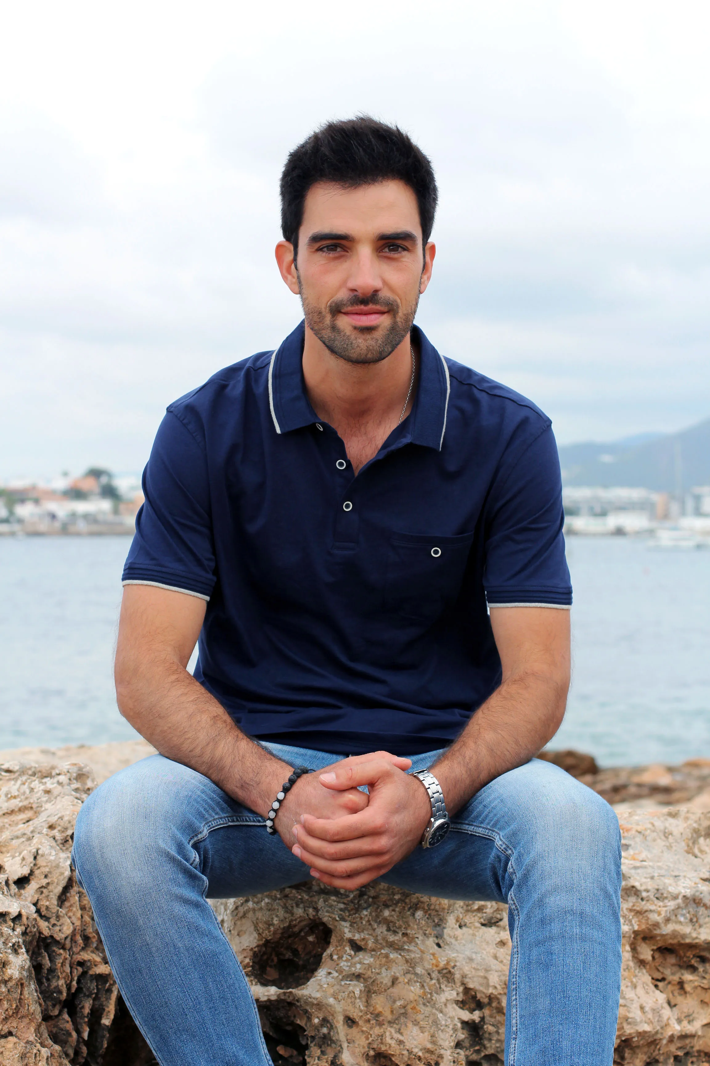 Mirko Abbruzzese sentado sobre las rocas del puerto de Ibiza